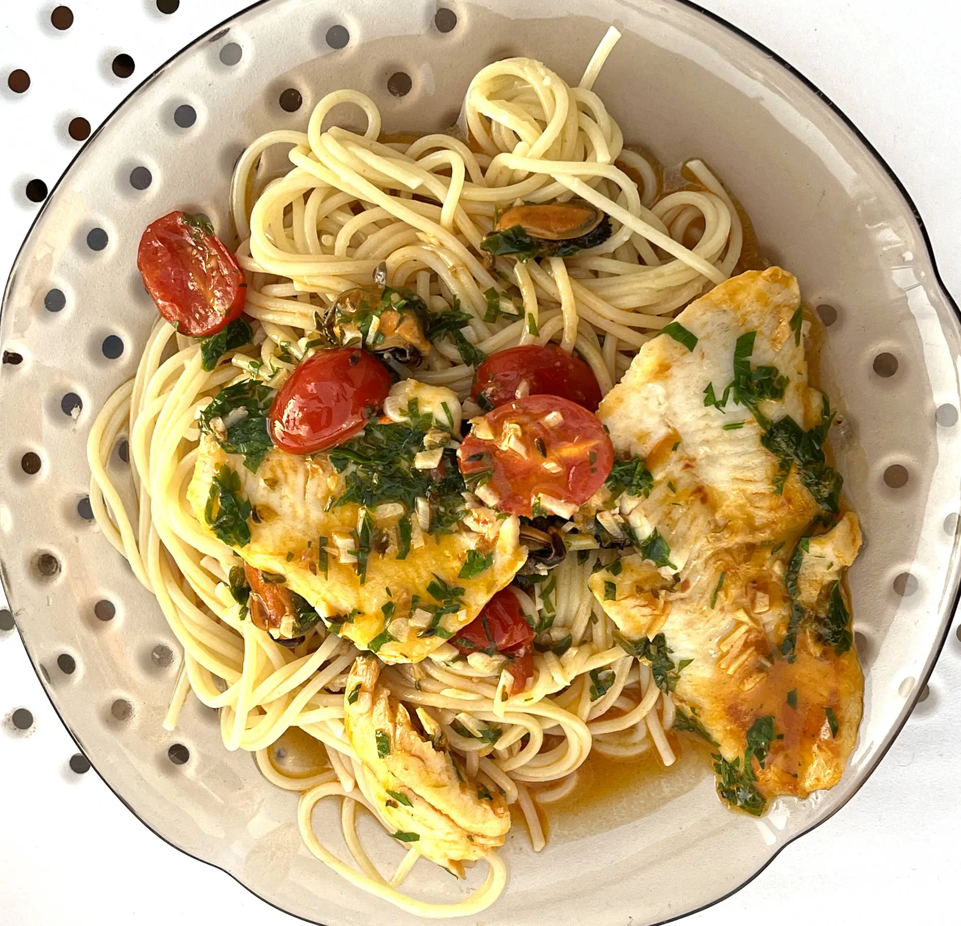 Merluza y mejillones sobre espaguetis” style=