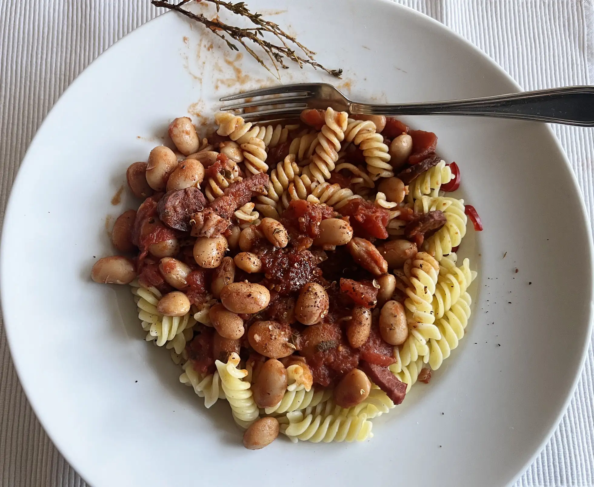 Bohnen mit Chorizo und Speck auf Fusilli” style=